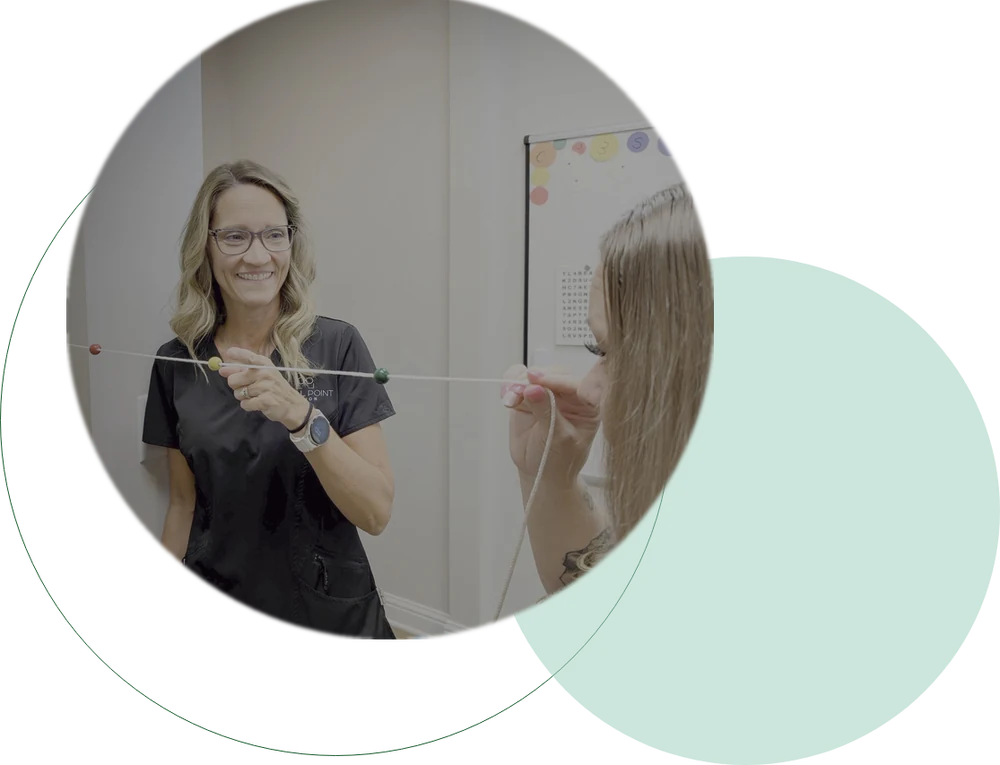 Optometrist guiding a vision therapy exercise at Focal Point Vision in Fairhope AL